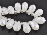 Perle de verre cristal, Goutte avec facettes et éclat. Dimension: +-14x8mm. Percée dans le sens de la largeur côté pointe. Couleur: Blanc Laiteux Code: D09216 --- Goutte avec facettes +-14x8mm. Blanc Laiteux---
