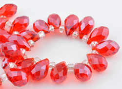 Perle de verre cristal, Goutte avec facettes et éclat. Dimension: +-14x8mm. Percée dans le sens de la largeur côté pointe. Couleur: Rouge Code: D09226 --- Goutte avec facettes +-14x8mm. Rouge---